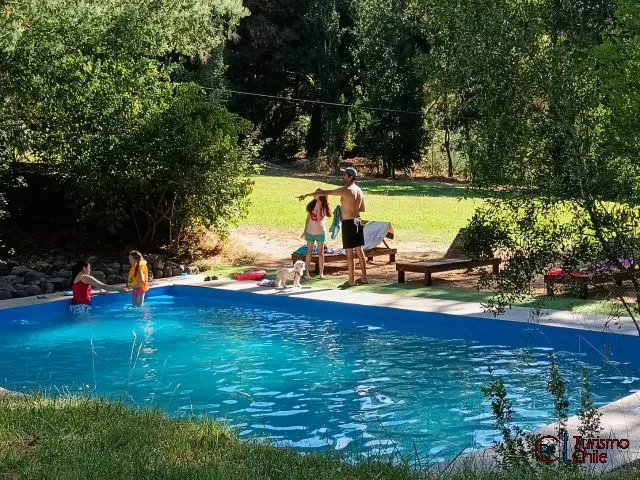 Vista de pradera verde con acantilado y río Laja al fondo